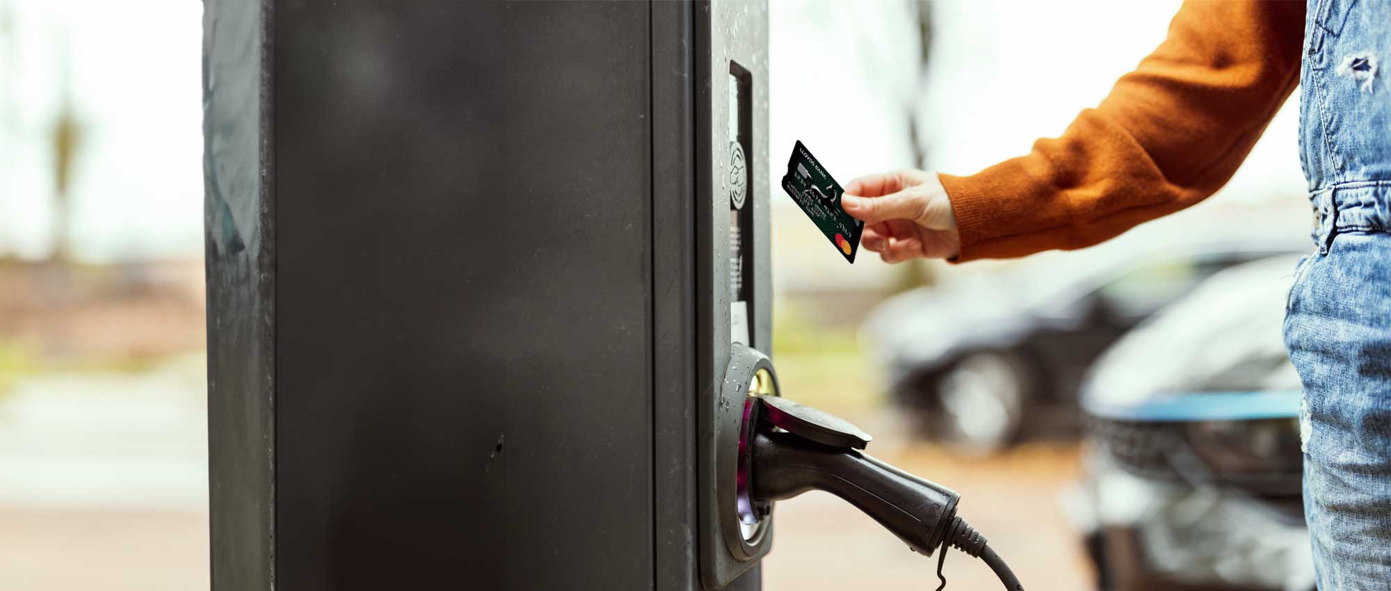 Image of a person holding a bank card to pay for Fuel