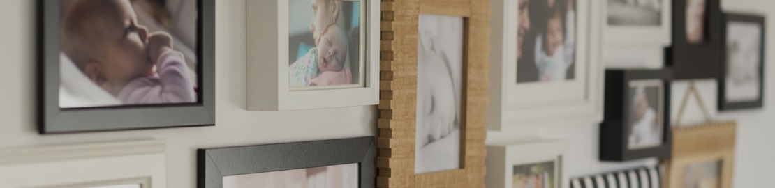 View of familiy photos, framed and pinned to a wall