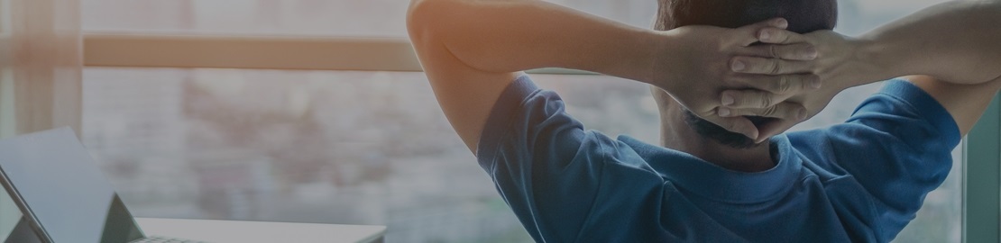 An image of a man looking out of the office window.