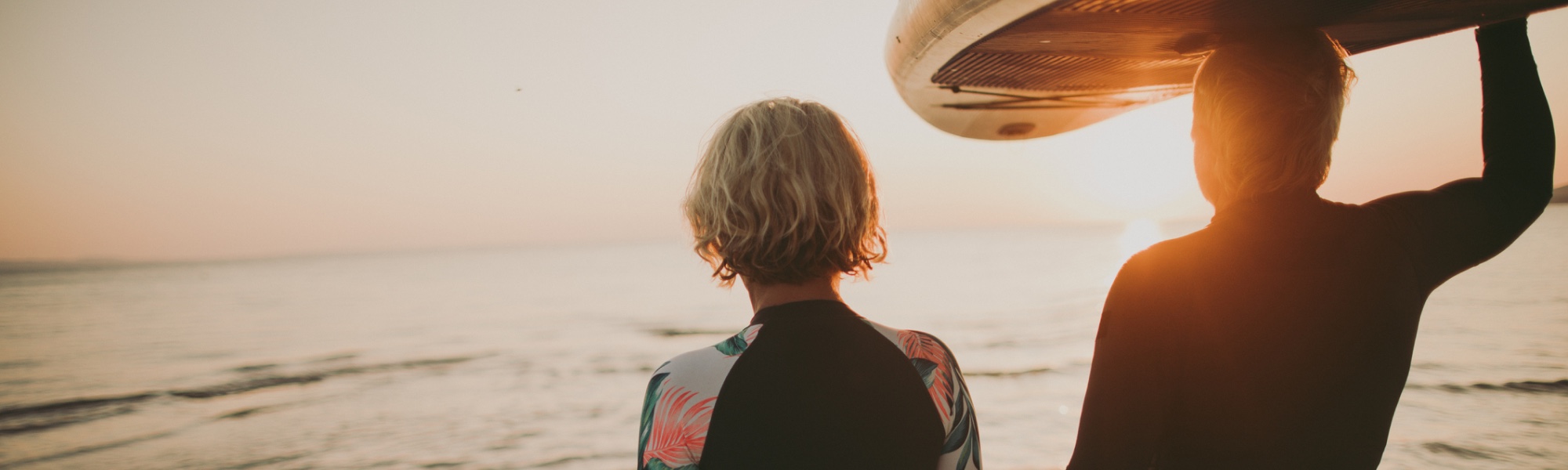 Couple looking out over the sea at the sunset