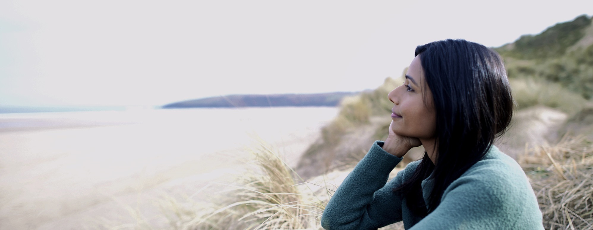 An image of a lady looking out to sea.